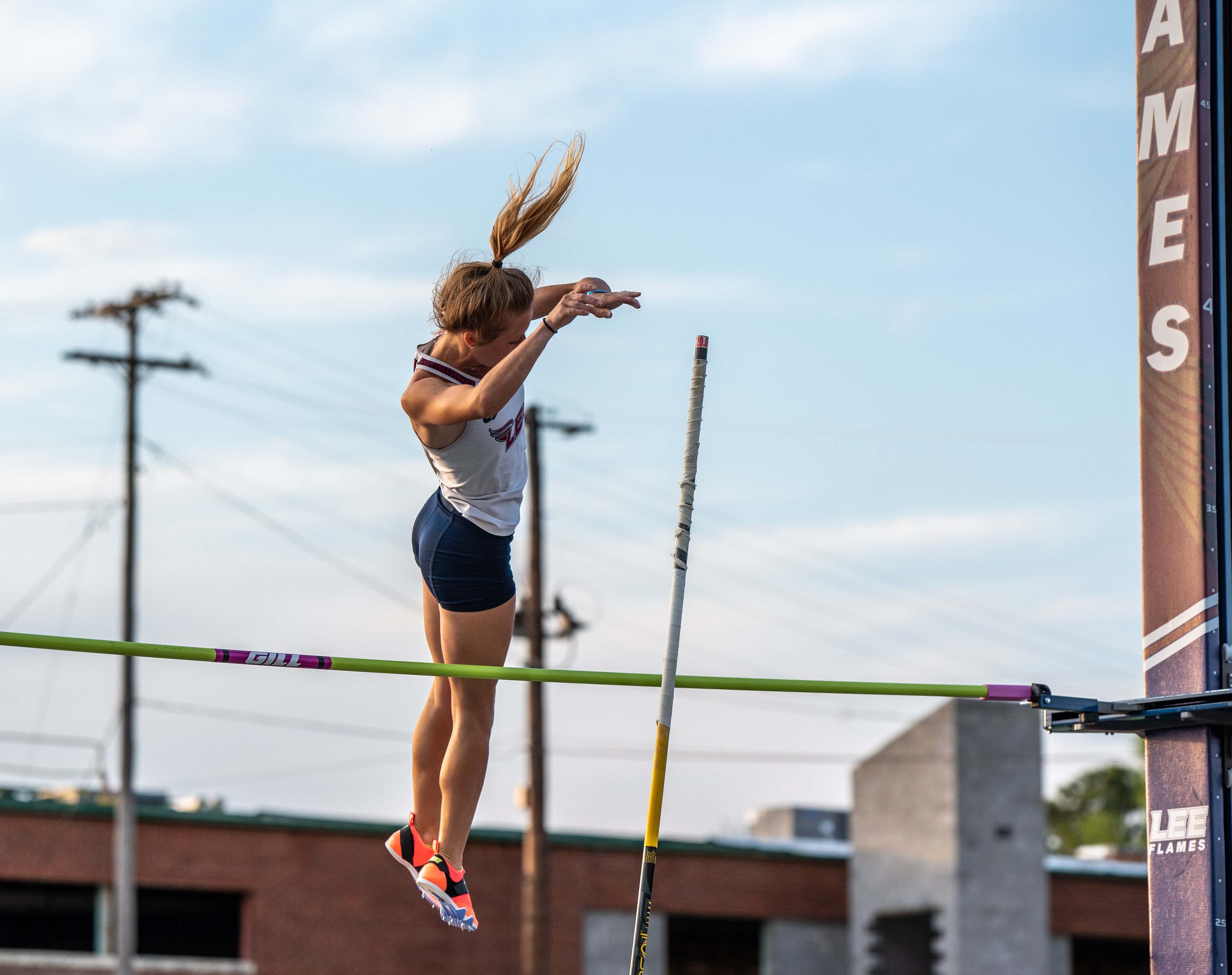 Female athlete pole vaulting at Lee Flames track meet