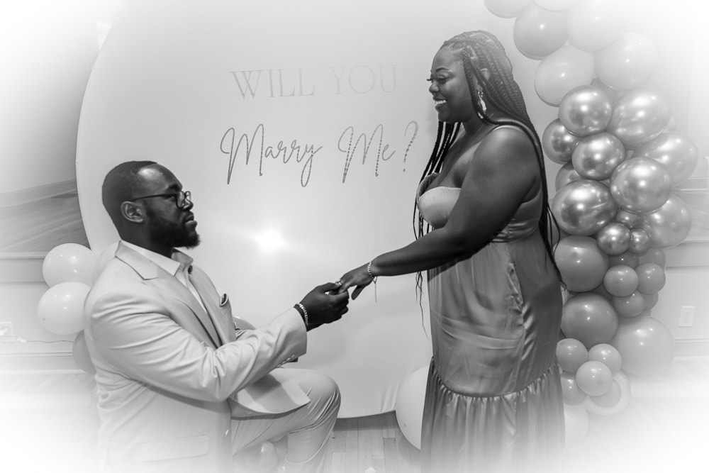 Black and white proposal moment with balloon backdrop