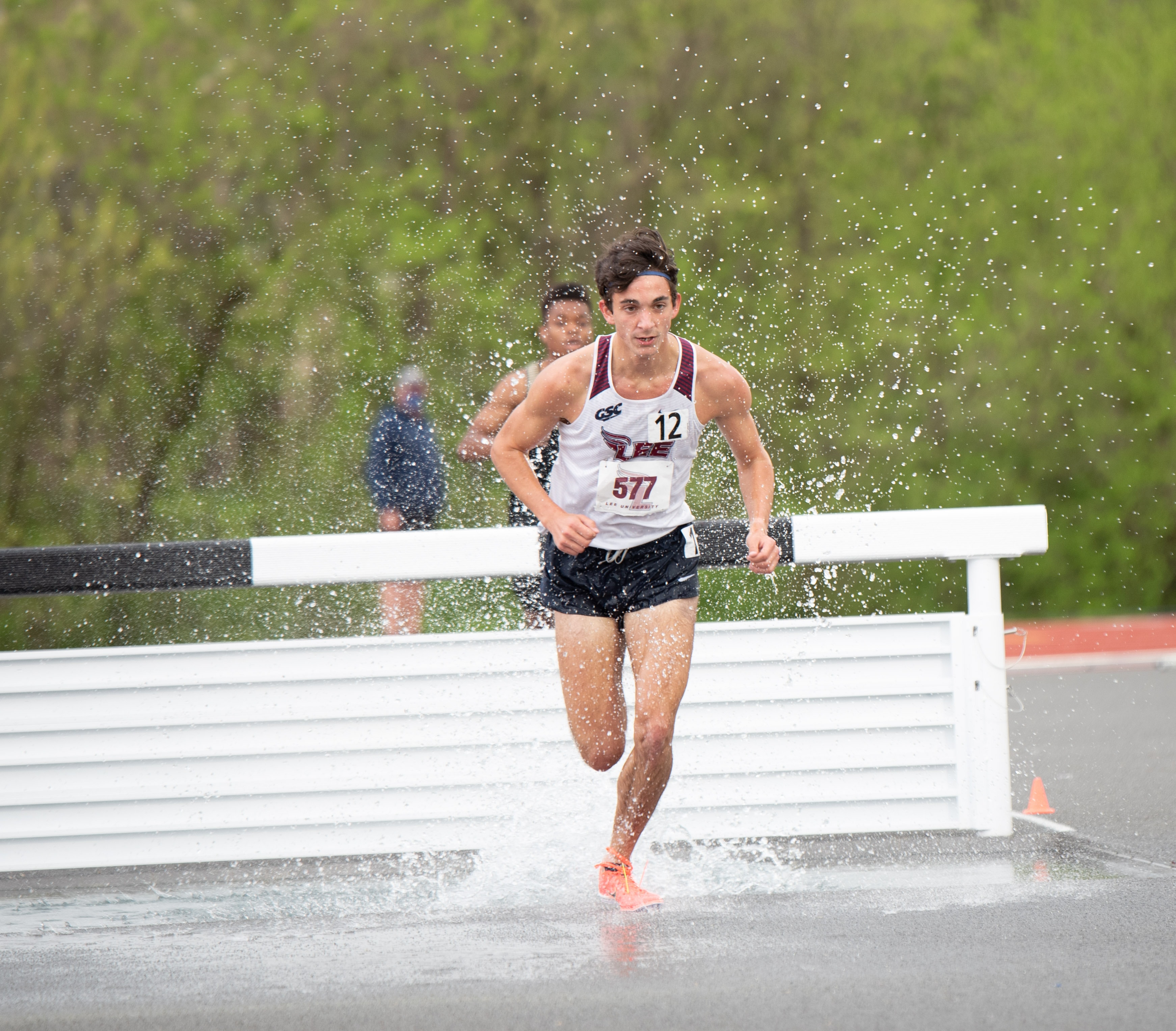 Lee University steeplechase runner splashing through water barrier