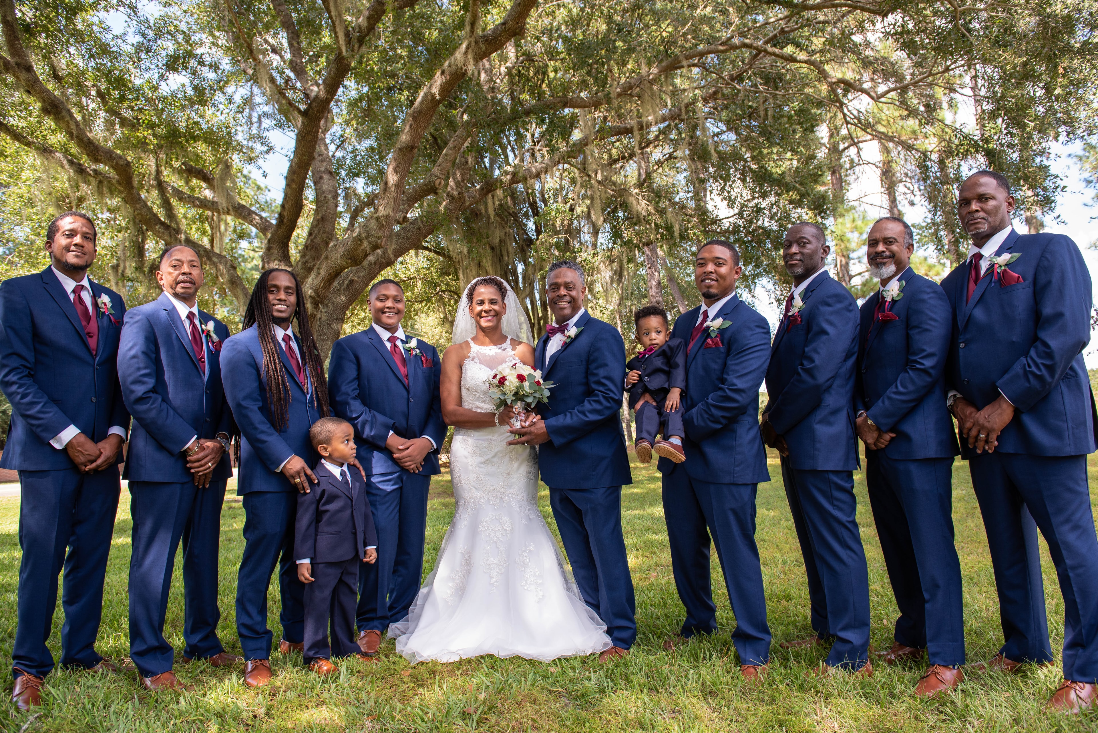 Bride and groom with groomsmen under a large oak tree